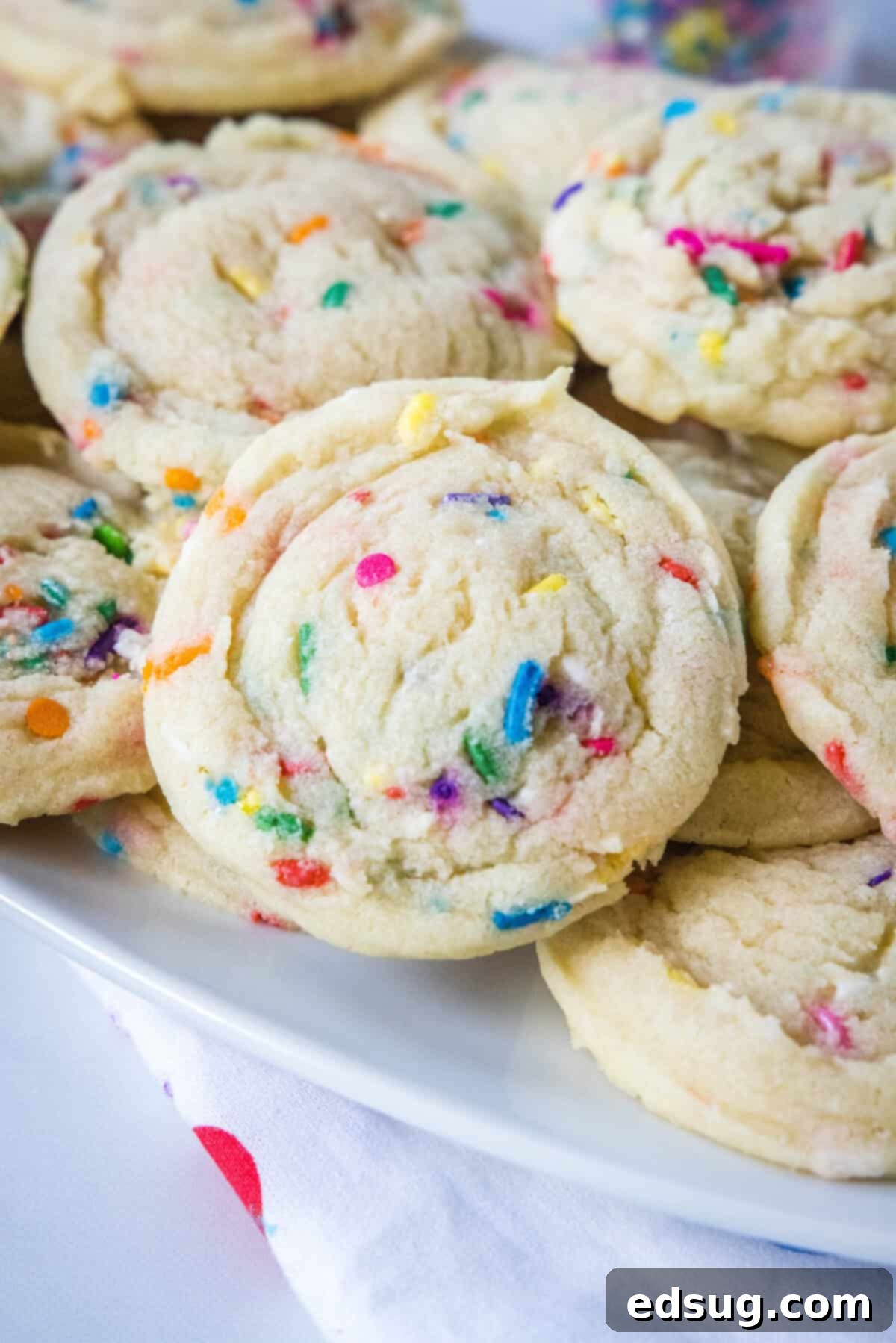 Whimsical Confetti Bites 2 Soft and chewy Funfetti cookies artfully arranged on a pristine white plate, showcasing their vibrant sprinkles.