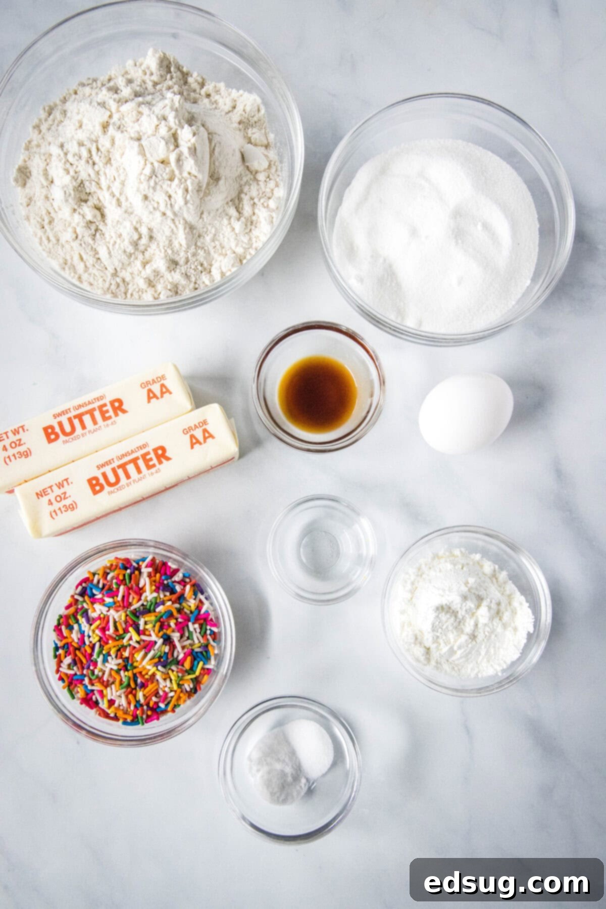 Whimsical Confetti Bites 3 A flat lay of all the fresh ingredients needed to bake a batch of delicious Funfetti cookies, neatly organized on a surface.