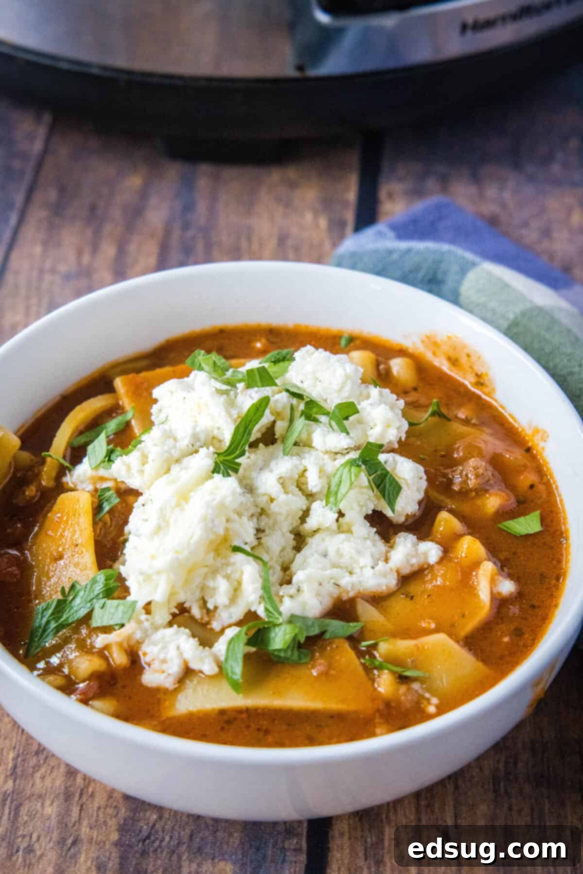 Hearty Slow Cooker Lasagna Soup 8 Close-up of a serving of slow cooker lasagna soup with ricotta topping and a spoon