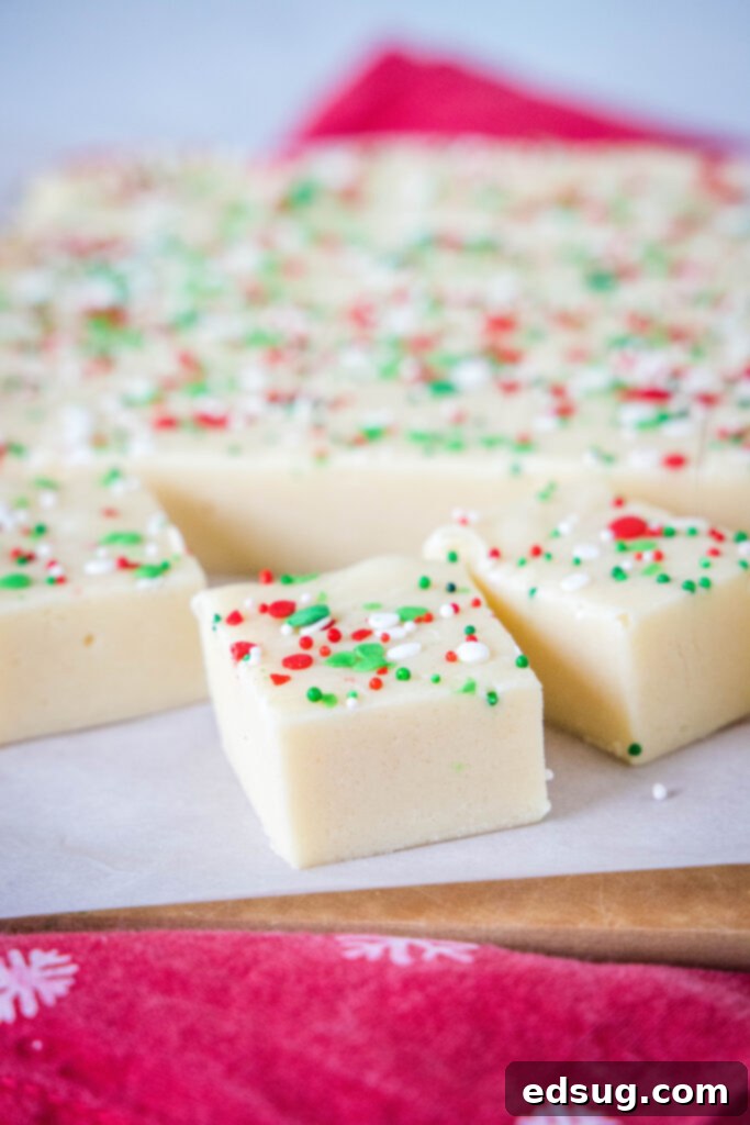 Frosted Sugar Cookie Fudge 2 A perfectly sliced piece of homemade sugar cookie fudge with colorful sprinkles on top, ready to be enjoyed.