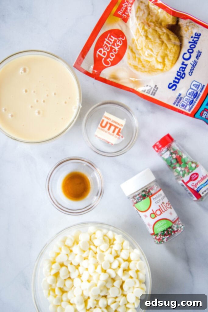 Frosted Sugar Cookie Fudge 3 All the simple ingredients laid out for making sugar cookie fudge, including sugar cookie mix, white chocolate chips, butter, sweetened condensed milk, vanilla extract, and colorful sprinkles.