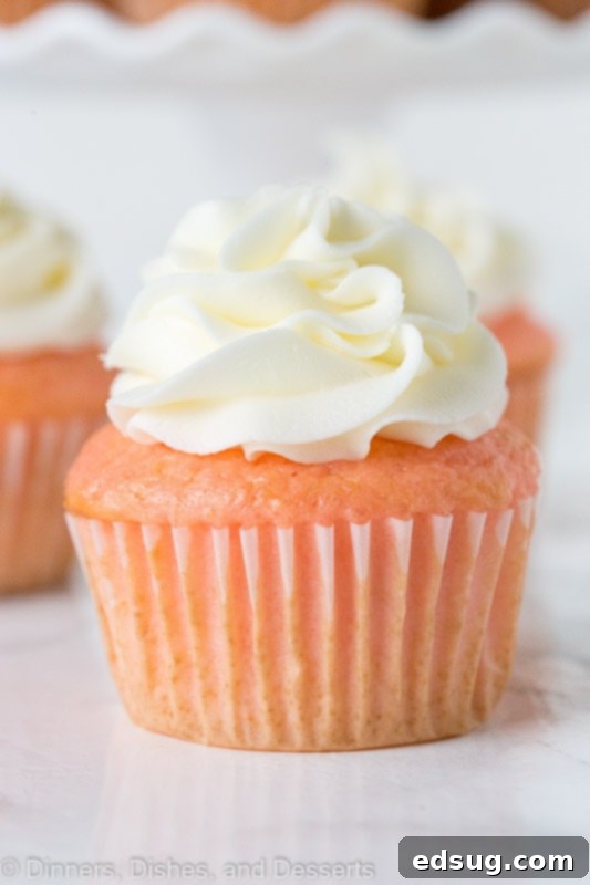 close up of strawberry almond cupcakes topped with frosting