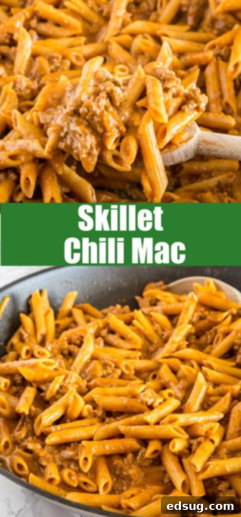 Extremely close-up shot of creamy, cheesy skillet chili mac with visible ground beef, penne pasta, and rich spices, showing the irresistible texture right from the skillet.
