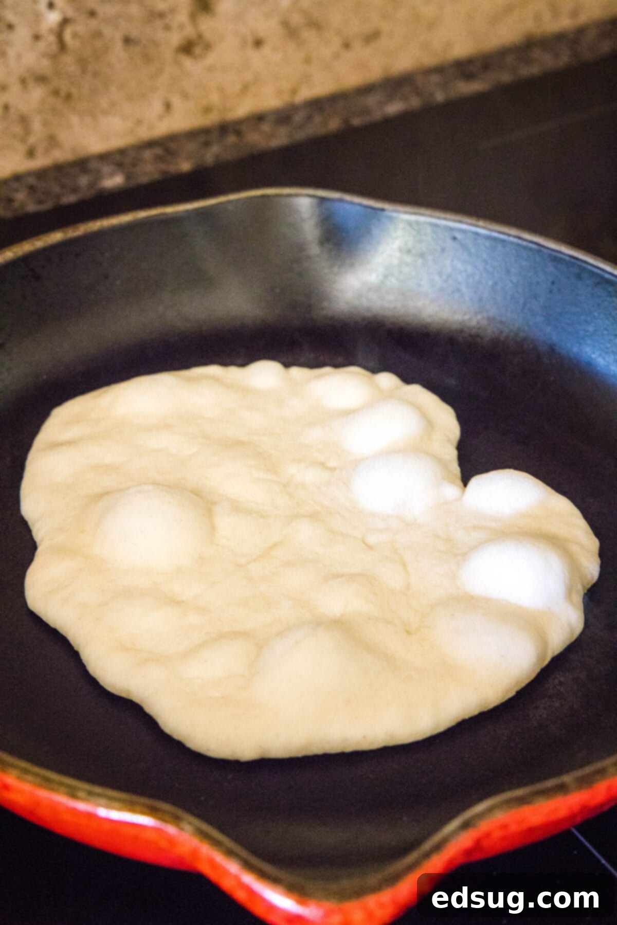 Crafting Perfect Pita 11 Another pita bread dough expanding and creating an air pocket on a sizzling hot skillet.