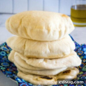 Crafting Perfect Pita 14 Fluffy homemade pita breads stacked on a blue cloth.