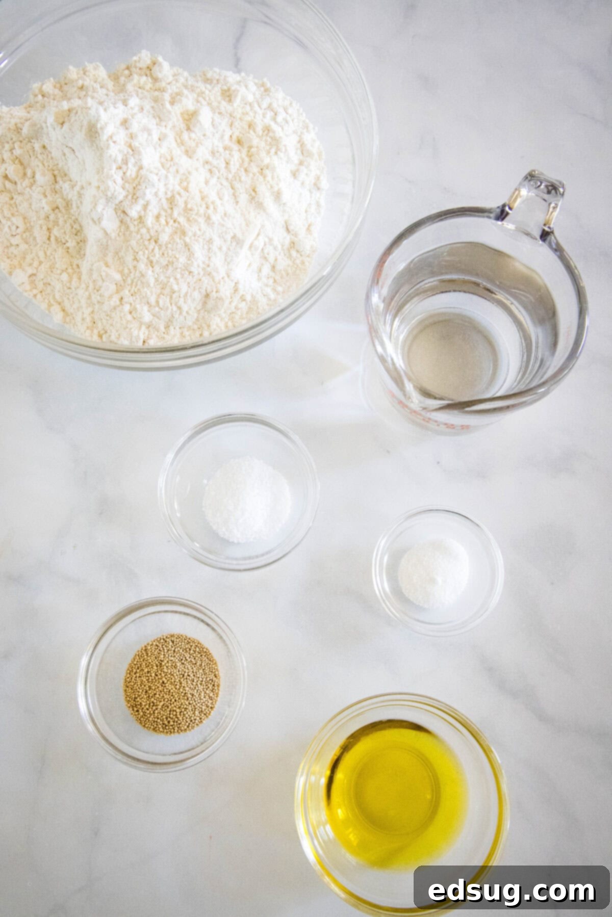 Crafting Perfect Pita 3 Six simple ingredients laid out for making homemade pita bread, including flour, olive oil, yeast, sugar, salt, and water.