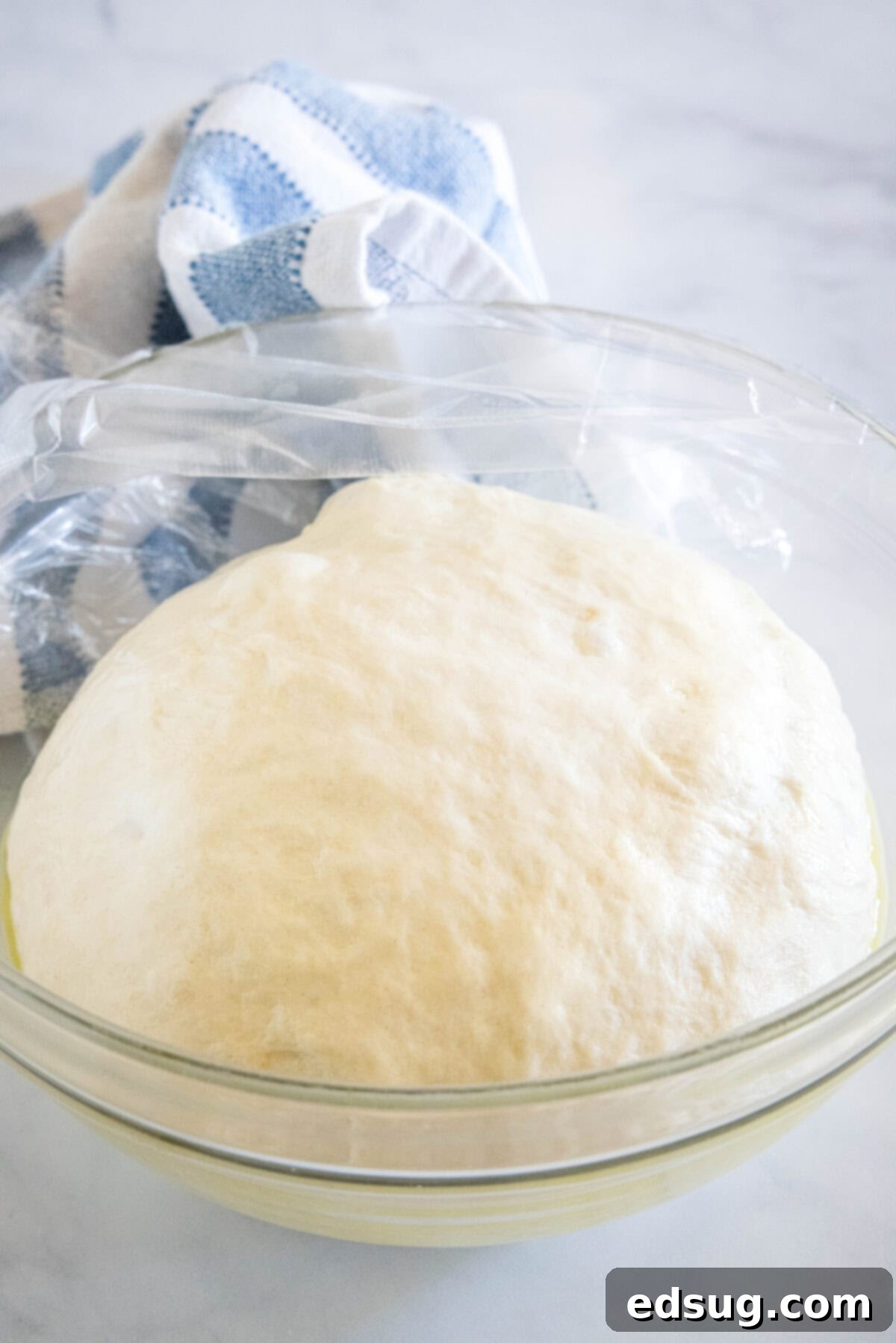 Crafting Perfect Pita 8 A ball of perfectly risen pita dough in a glass bowl, doubled in size and ready for shaping.