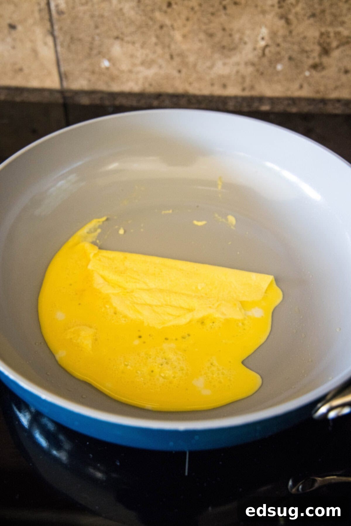folding eggs into thirds in a skillet