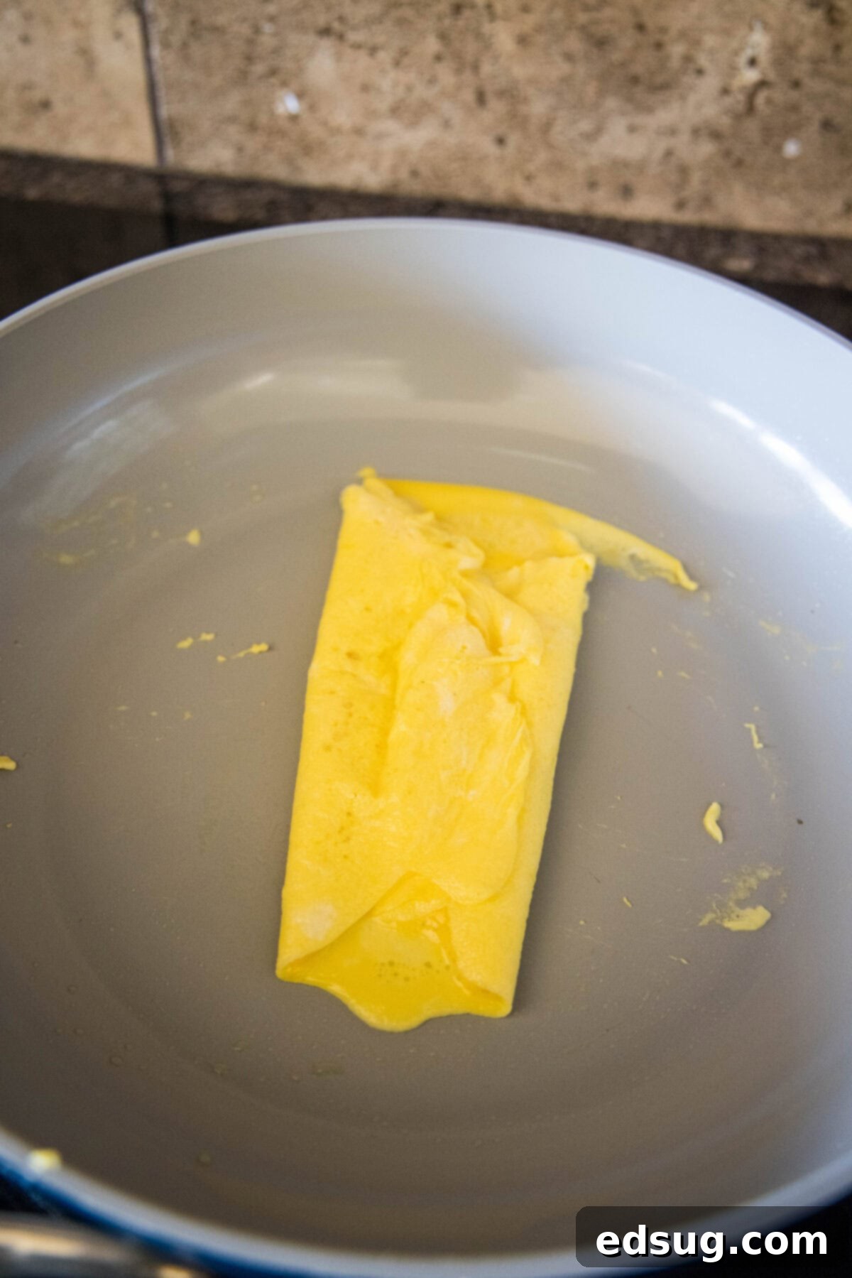 folding eggs into thirds in a skillet