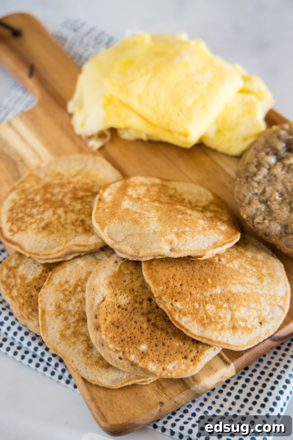 pancakes sausage and eggs on a cutting board