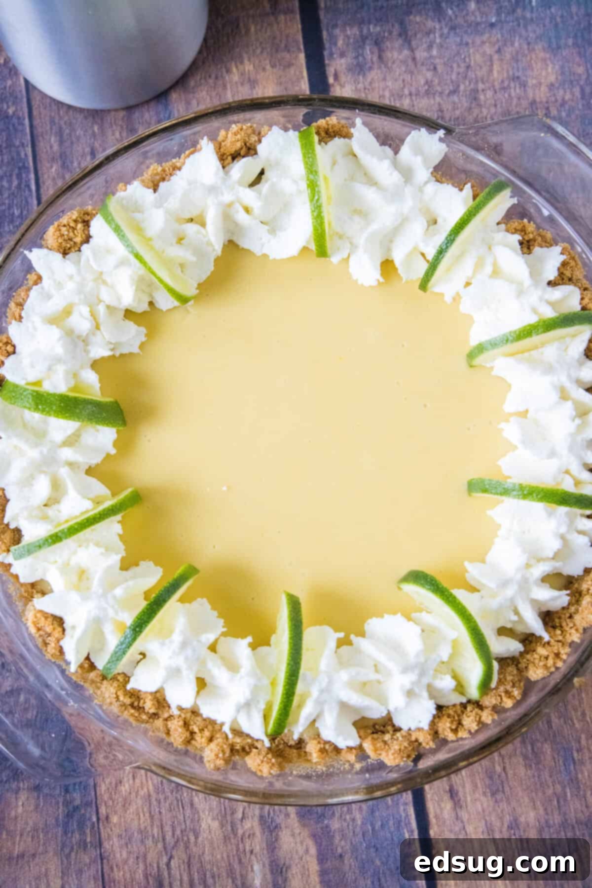 looking down on key lime pie with whipped cream and lime slices