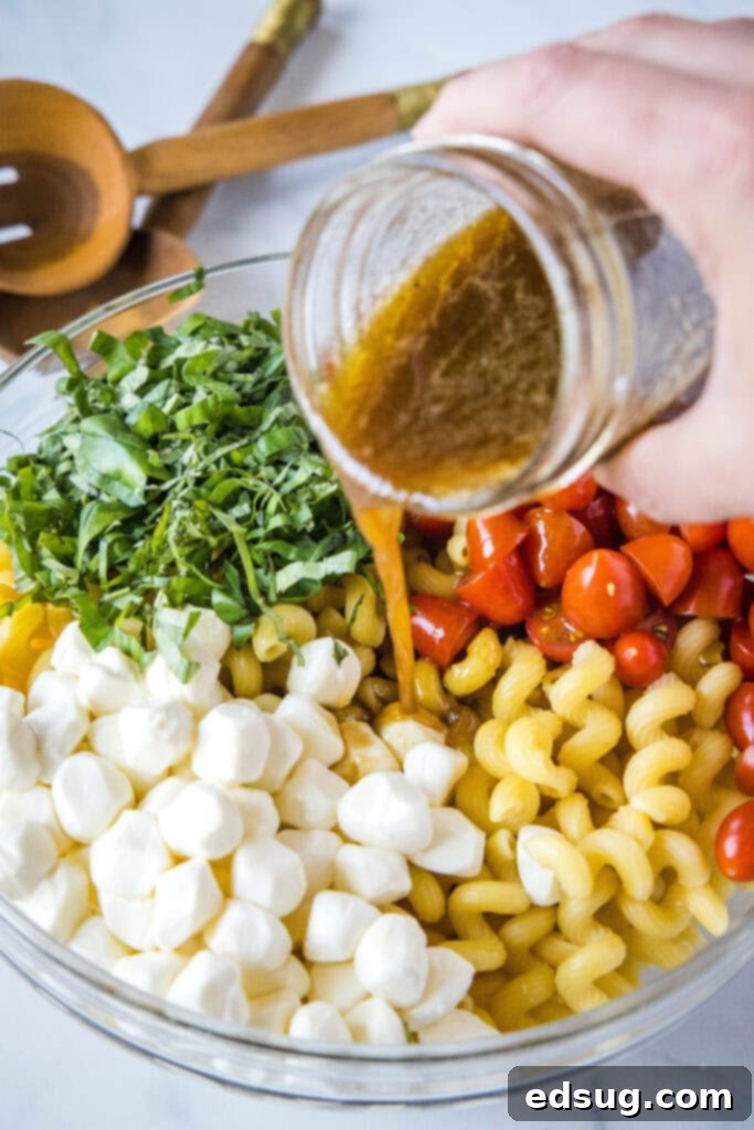 pouring dressing into bowl of pasta salad