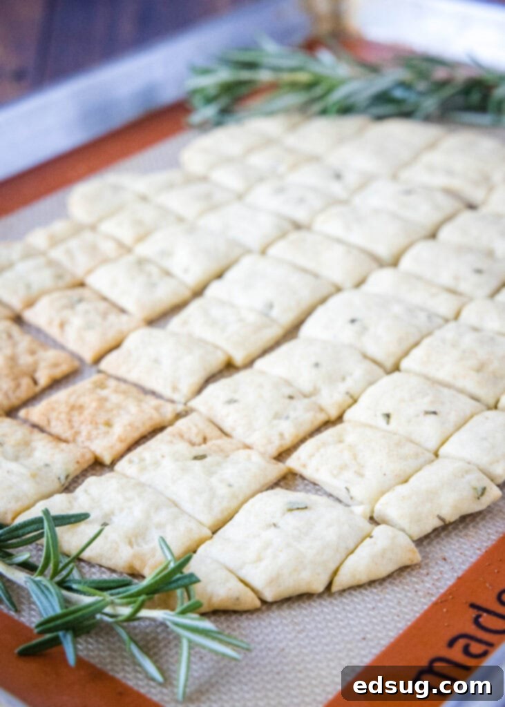 Mediterranean Rosemary Olive Oil Crackers 3 Rosemary crackers cooling on a baking mat, ready to be broken apart.