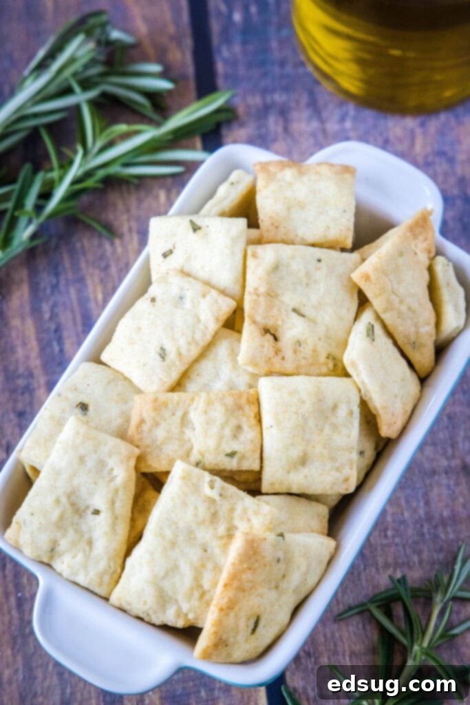 Mediterranean Rosemary Olive Oil Crackers 5 A bowl of homemade rosemary olive oil crackers with fresh rosemary sprigs, ready for serving.