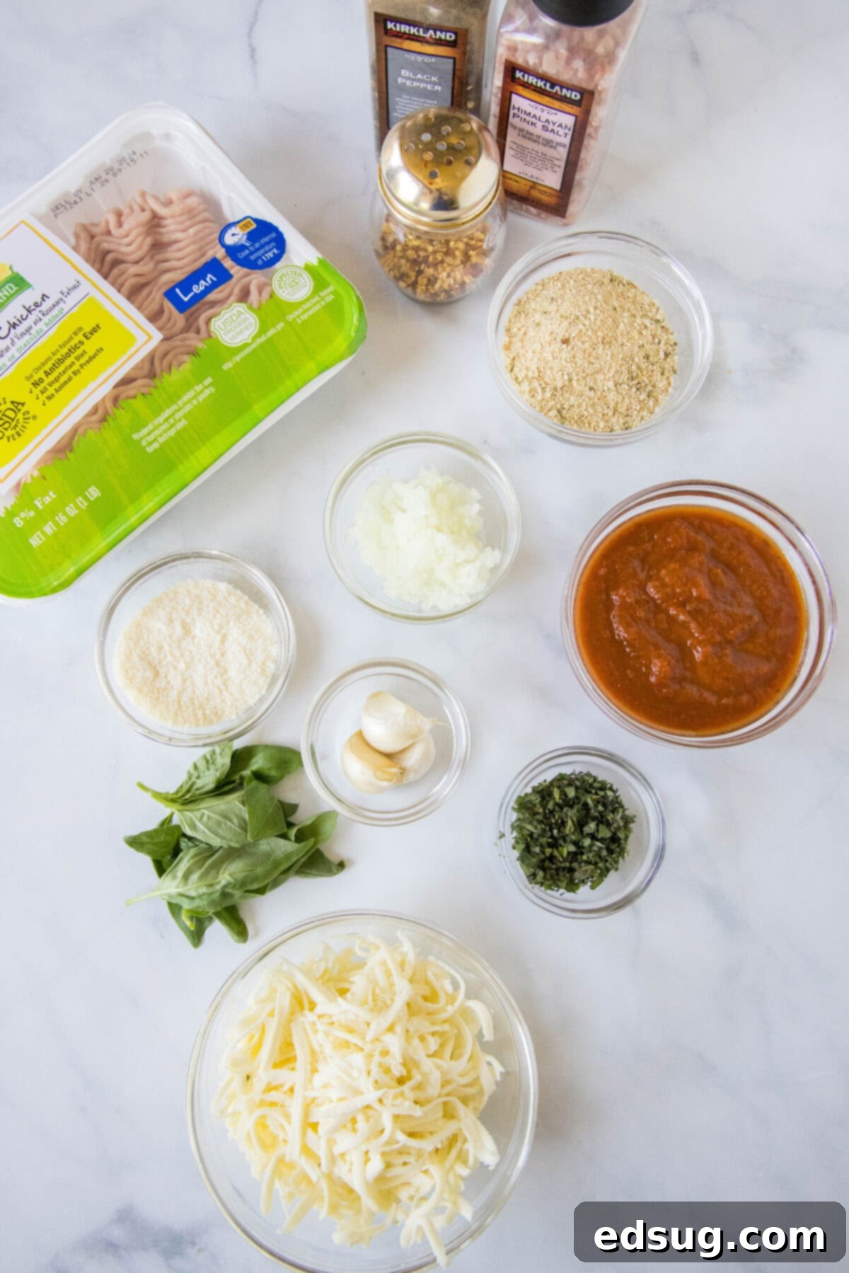 Chicken Parm Burgers 3 Ingredients laid out for Chicken Parmesan Burgers, including ground chicken, marinara, cheese, basil, onion, garlic, and breadcrumbs.