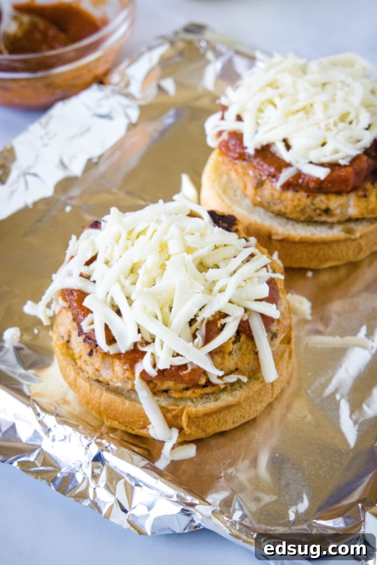 Chicken Parm Burgers 5 Assembled Chicken Parmesan Burgers topped with marinara and mozzarella, ready to be placed under the broiler.