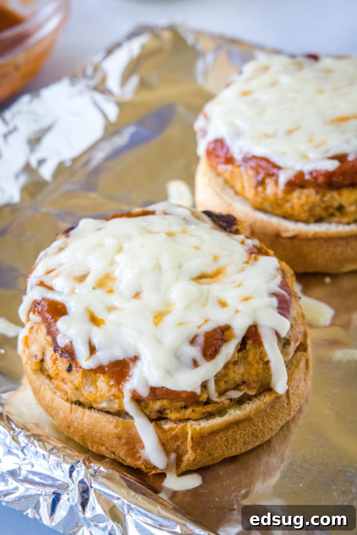 Chicken Parm Burgers 6 Close-up of a Chicken Parmesan Burger with perfectly melted mozzarella and fresh basil, ready to eat.