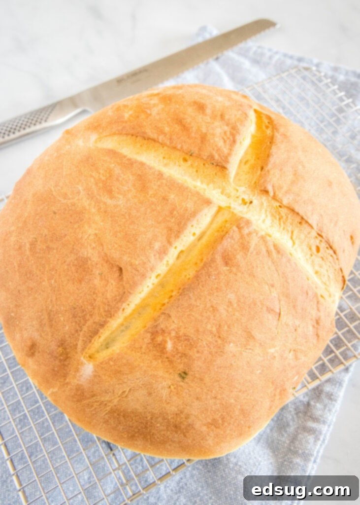 Savory Potato Chive Loaf 3 A freshly baked loaf of golden-brown potato bread with a crispy crust, cooling on a wire rack.