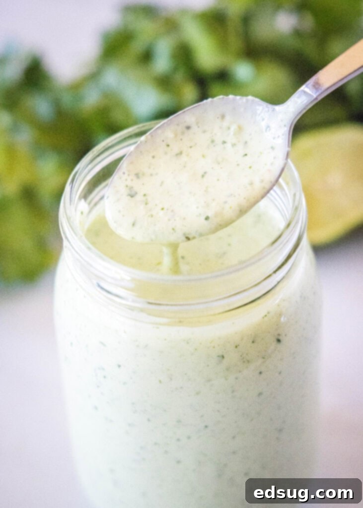 Signature Cafe Rio Dressing 2 spooning tomatillo ranch dressing out of a jar
