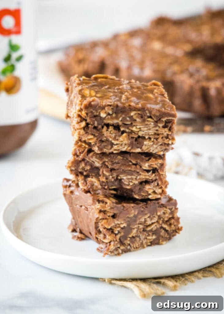 Dreamy No-Bake Nutella Bars 5 A stack of golden brown no-bake Nutella bars presented on a clean white plate, ready to be enjoyed.