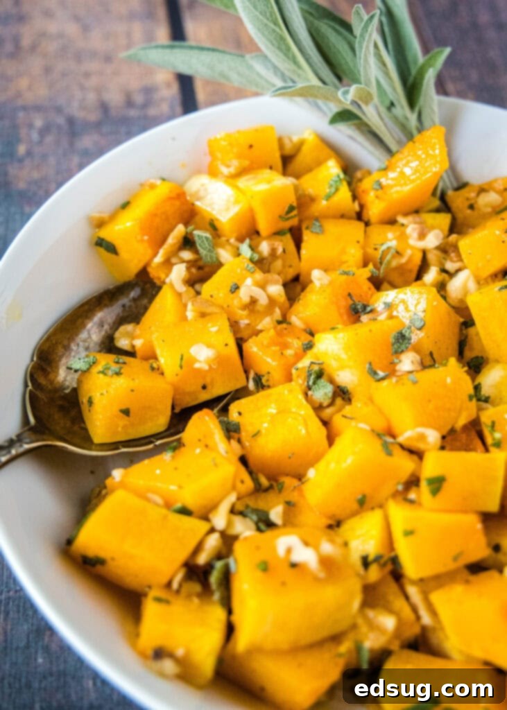a spoon scooping out pieces of squash from a white bowl