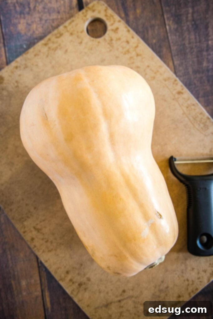 butternut squash on a cutting board ready to be peeled