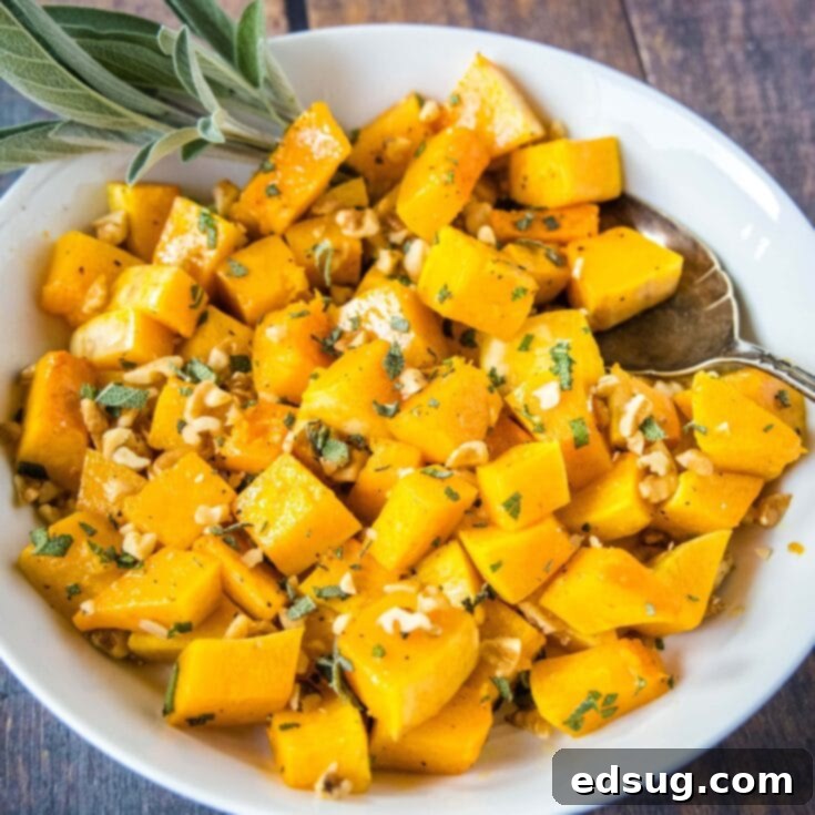 close up butternut squash in a bowl with a sprig of sage