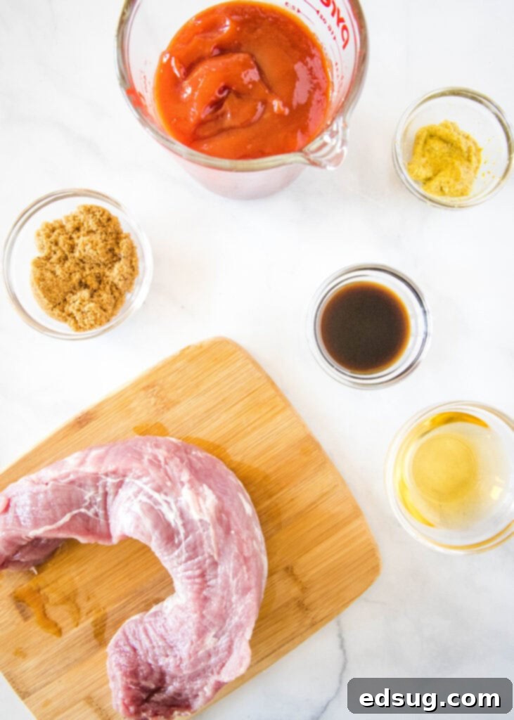 An array of fresh ingredients for slow cooker pulled pork sandwiches, including pork tenderloin, ketchup, brown sugar, apple cider vinegar, Worcestershire sauce, spicy brown mustard, and black pepper, arranged neatly on a wooden surface.