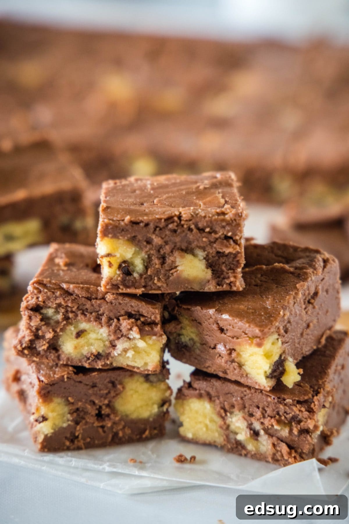 Cookie Dough Dream Fudge 2 Stacks of rich chocolate cookie dough fudge on a wooden cutting board