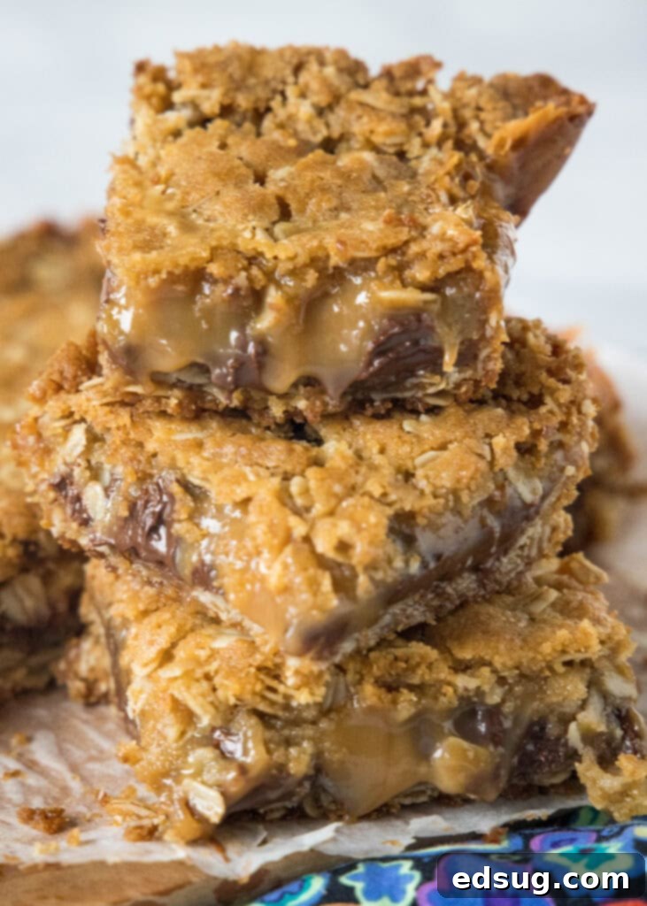 Chewy Caramel Bars 6 Several Caramelitas stacked on a wooden cutting board, highlighting their thick, delicious layers of oatmeal, chocolate, and caramel