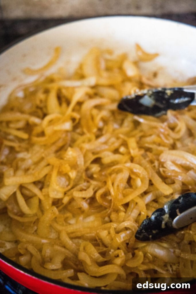 Caramelized French Onion Pork Chops 4 caramelized onions simmering in a pan, turning golden brown