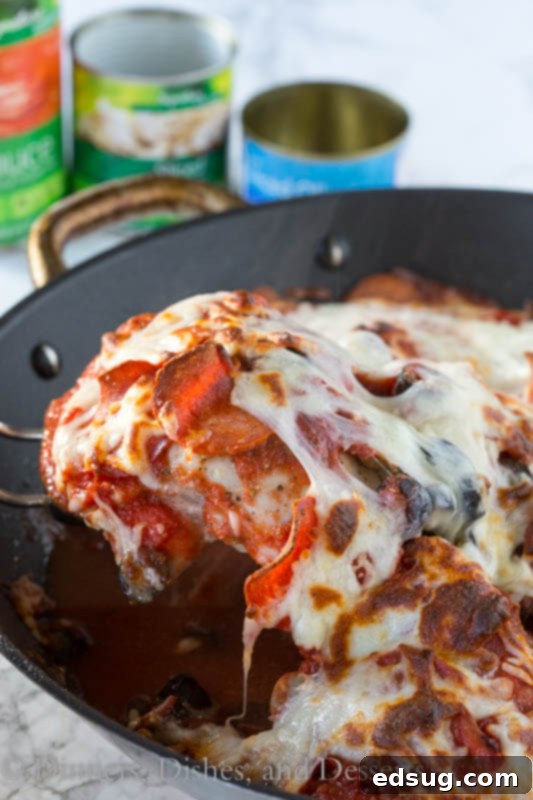 One Pan Pizza Chicken in a skillet, bubbling with melted cheese, pepperoni, mushrooms, and olives