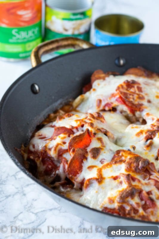 Close-up of baked One Pan Pizza Chicken, with bubbling cheese and crispy pepperoni edges