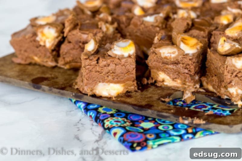 Overhead shot of Creme Egg Fudge in a baking dish, with chopped Cadbury Creme Eggs spread across the bottom, ready for the fudge mixture