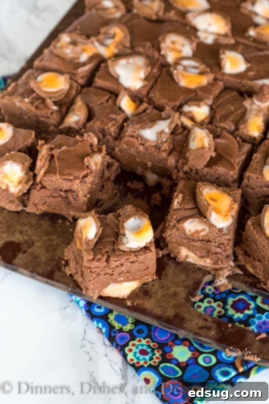 Close-up of a perfectly cut square of Creme Egg Fudge, revealing the creamy texture and colorful Cadbury Creme Egg pieces inside