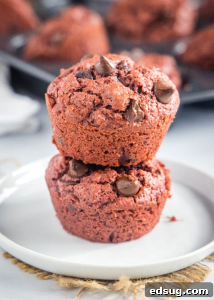 Decadent Red Velvet Muffins 2 stacked red velvet muffins on a white plate