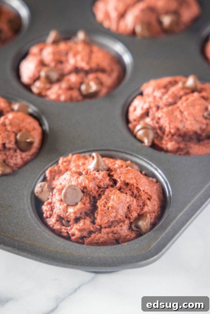 Decadent Red Velvet Muffins 3 baked muffins in a muffin tin