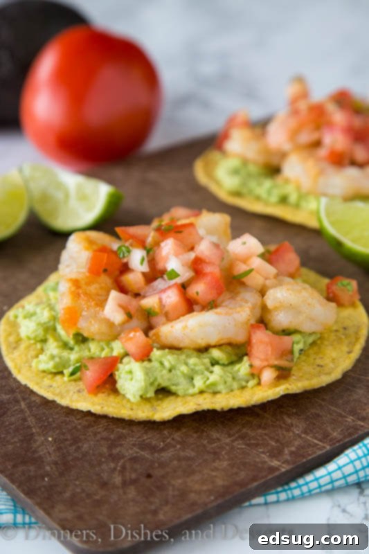 Zesty Shrimp and Avocado Tostadas 2 A close up of shrimp tostadas garnished with cilantro and lime