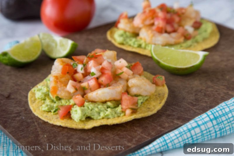 Zesty Shrimp and Avocado Tostadas 3 shrimp tostadas on a cutting board with fresh ingredients
