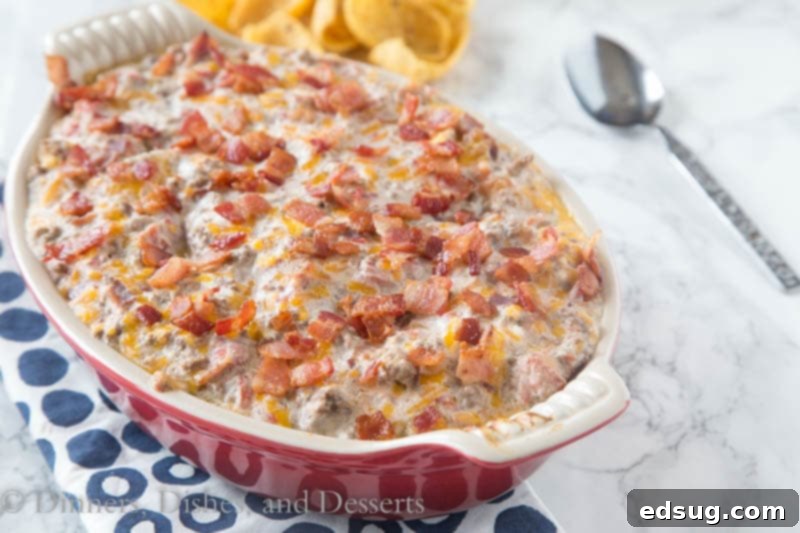 Ultimate Bacon Cheeseburger Dip 3 A large ceramic dish filled with bubbling, hot Bacon Cheeseburger Dip, garnished with extra bacon and green onions, ready for serving.