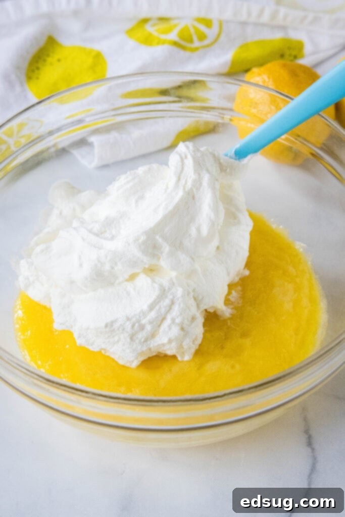 Zesty Lemon Cloud 6 adding whipped cream to chilled lemon mousse mixture in a bowl