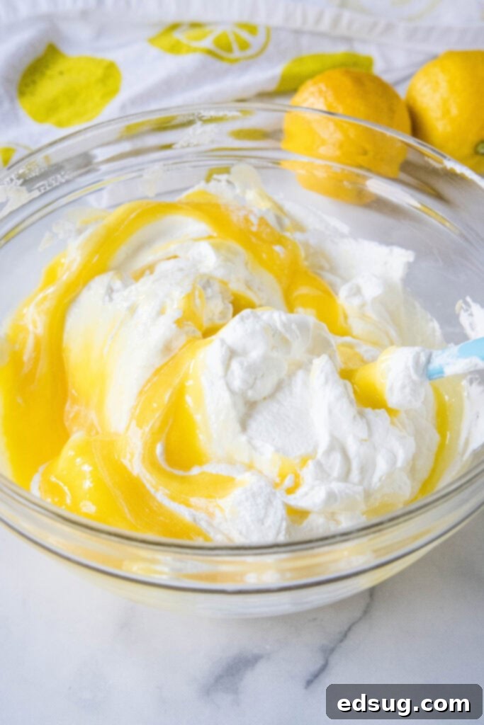 Zesty Lemon Cloud 7 folding together lemon mousse and whipped cream with a spatula