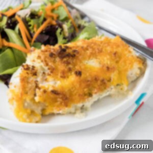 Baked ranch chicken served with a side of salad on a white plate.