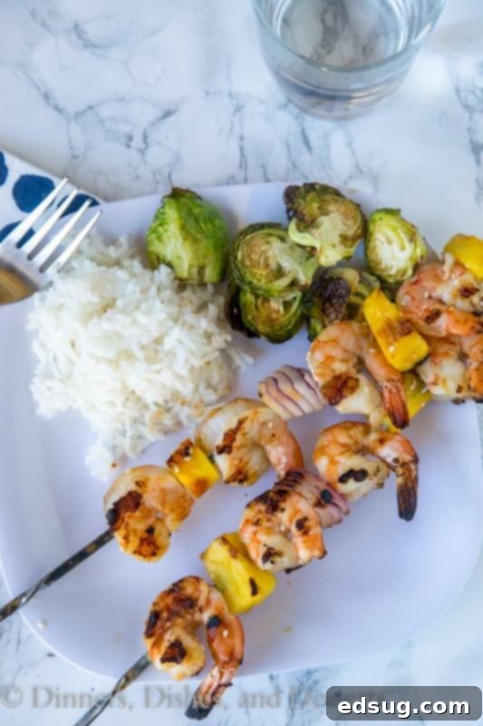 Teriyaki Grilled Shrimp Skewers 5 Plated grilled teriyaki shrimp kebabs with a side of rice