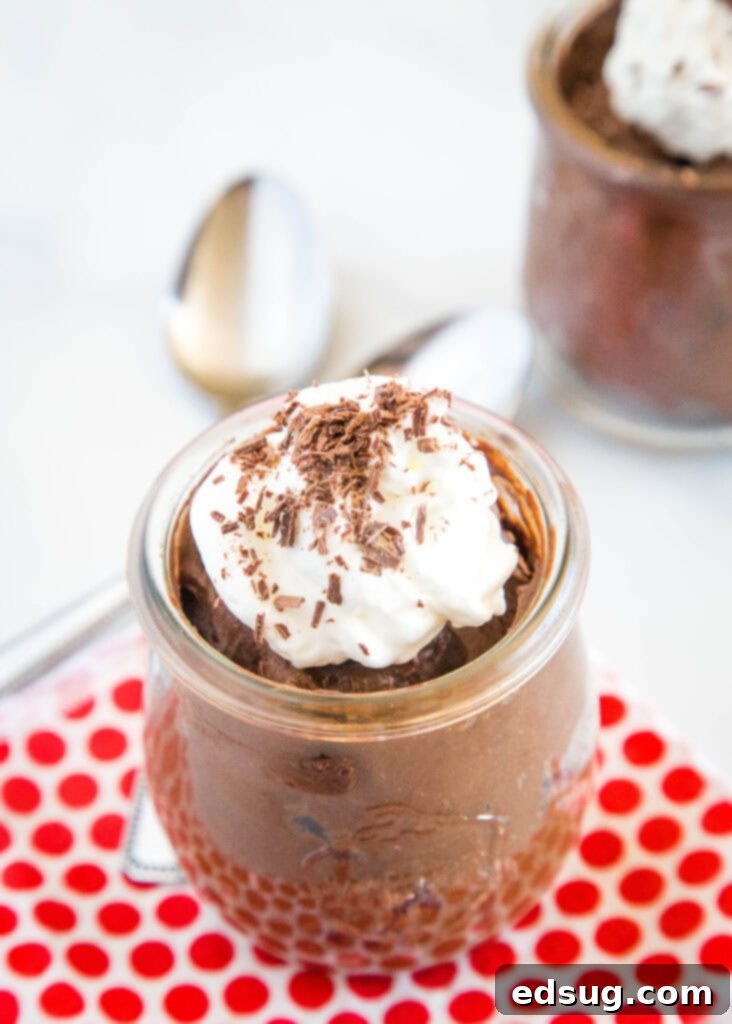 Velvet Chocolate Indulgence 2 Rich and creamy avocado chocolate mousse topped with whipped cream and delicate chocolate shavings, served in elegant glasses.