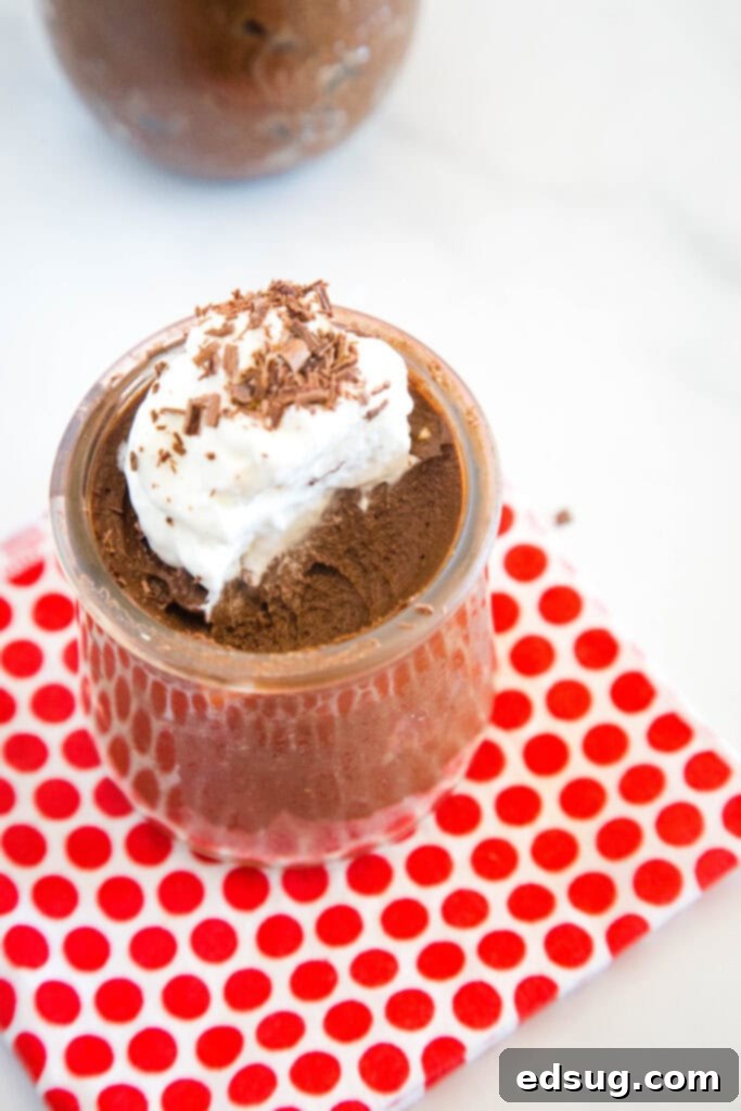 Velvet Chocolate Indulgence 6 A jar of avocado chocolate mousse with a portion scooped out, showing its rich, set texture.