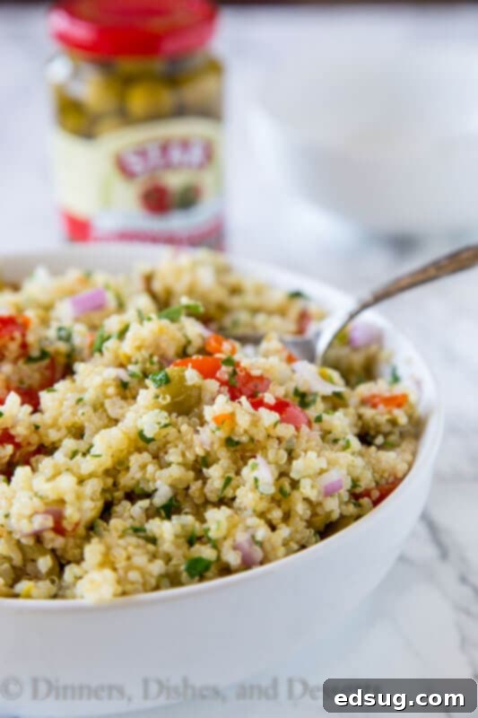 Zesty Mediterranean Quinoa Bowl 2 A vibrant Mediterranean quinoa salad in a large serving bowl, garnished with fresh herbs and lemon wedges.