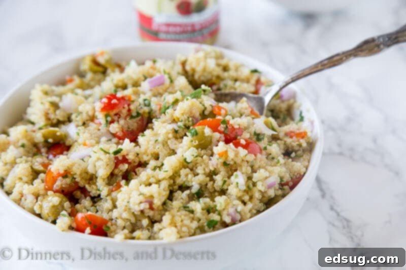 Zesty Mediterranean Quinoa Bowl 3 Close-up of Mediterranean quinoa salad with green olives and tomatoes in a bowl, showcasing fresh ingredients.