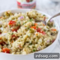 Zesty Mediterranean Quinoa Bowl 7 A beautifully presented Mediterranean Quinoa Salad, vibrant with tomatoes, green olives, and fresh herbs, ready to be served.