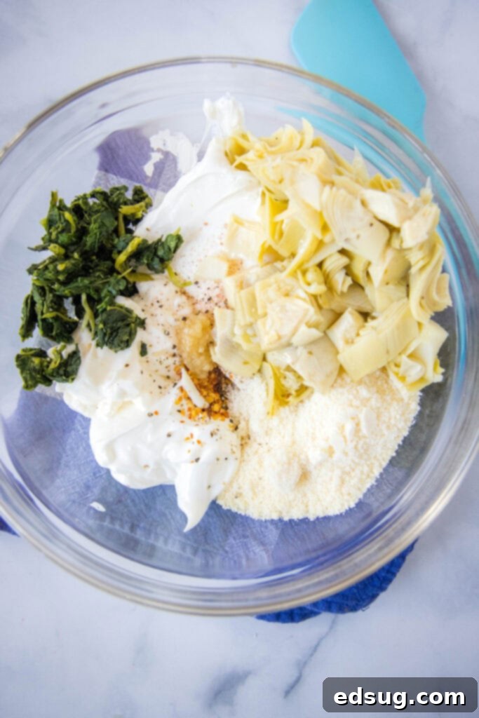 Creamy Spinach Artichoke Dip 4 spinach artichoke dip ingredients mixed in a bowl